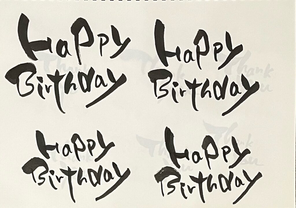 筆ペンで「Happy　Birthday」と練習したスケッチブックの写真　